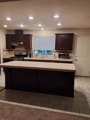 a kitchen with stainless steel appliances a stove a sink a microwave and cabinets