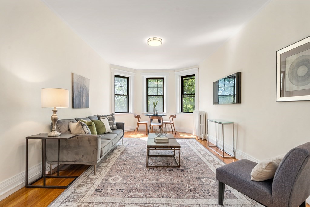 a living room with furniture and wooden floor