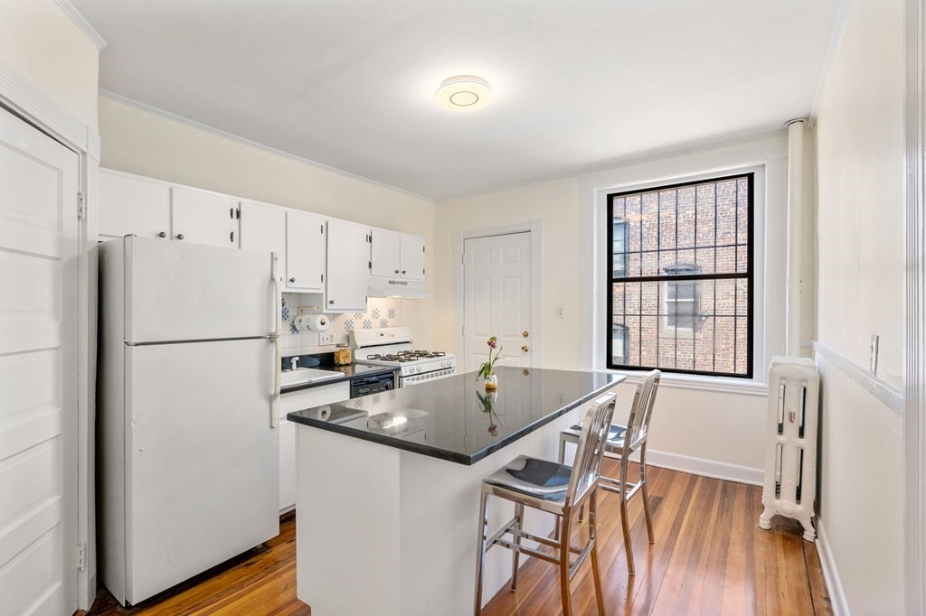 384 Riverway, Unit 5 Boston, MA 02115 - Photo 12 of 20 a kitchen with stainless steel appliances a refrigerator sink and cabinets