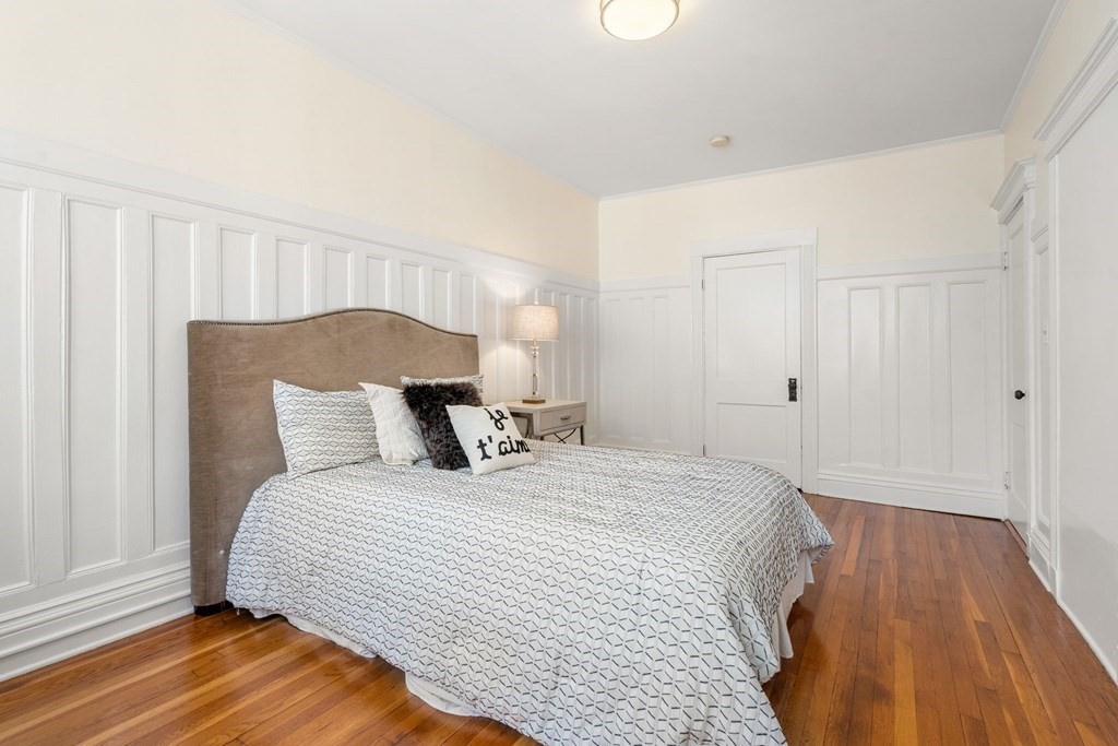 384 Riverway, Unit 5 Boston, MA 02115 - Photo 4 of 20 a bedroom with a bed and wooden floor