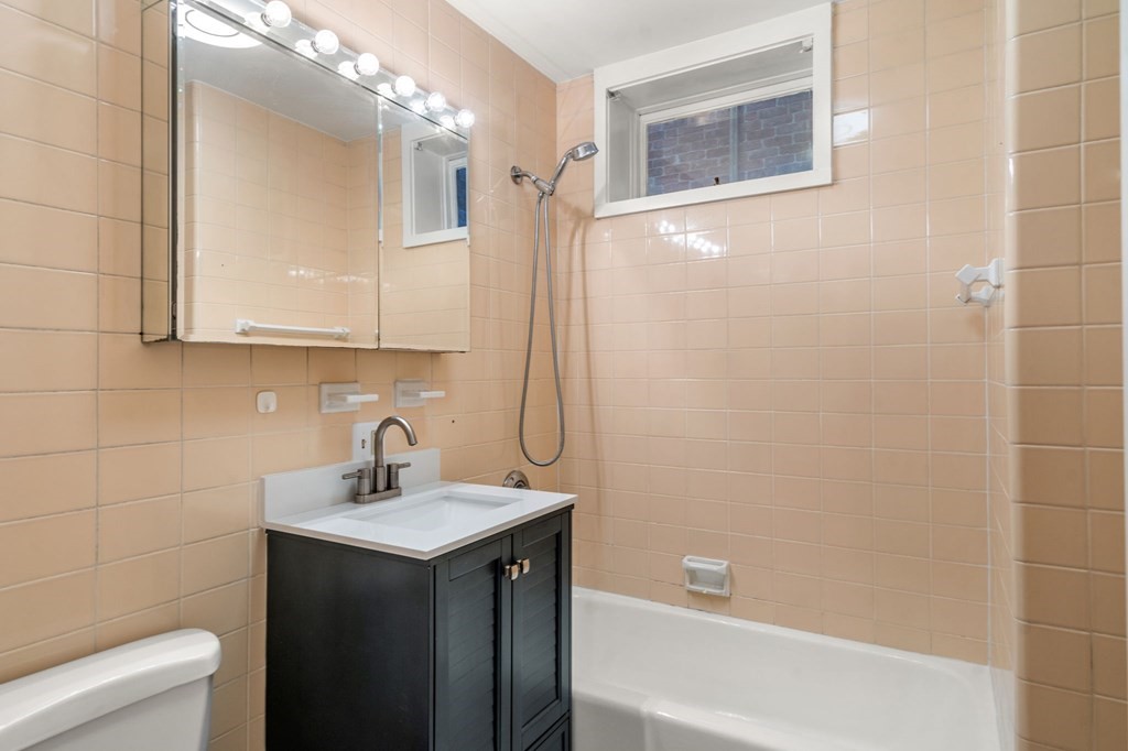 384 Riverway, Unit 5 Boston, MA 02115 - Photo 7 of 20 a bathroom with a sink a toilet and shower