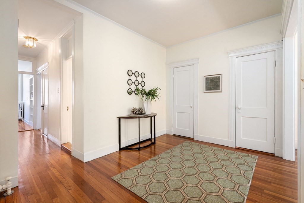 384 Riverway, Unit 5 Boston, MA 02115 - Photo 8 of 20 a view of a hallway with wooden floor and a potted plant