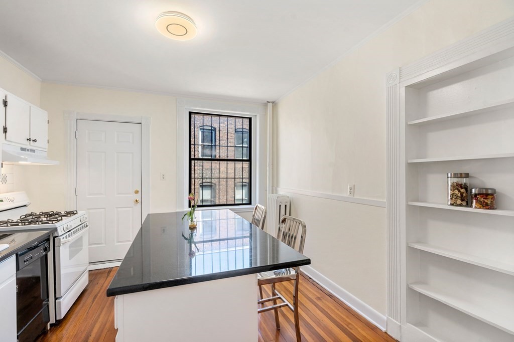 384 Riverway, Unit 5 Boston, MA 02115 - Photo 10 of 20 a kitchen with stainless steel appliances granite countertop a stove a sink and a refrigerator
