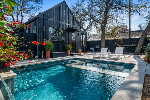 a view of swimming pool with sitting area and garden