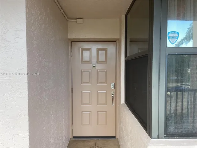 a view of a building with potted plants and palm trees