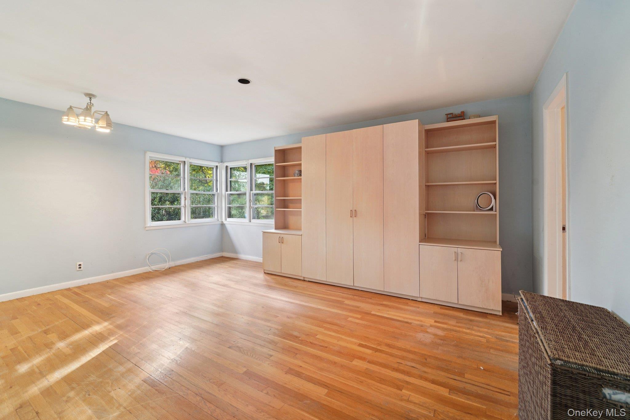 24 Pamela Lane New Rochelle, NY 10804 - Photo 17 of 34 a view of an empty room with a window and wooden floor