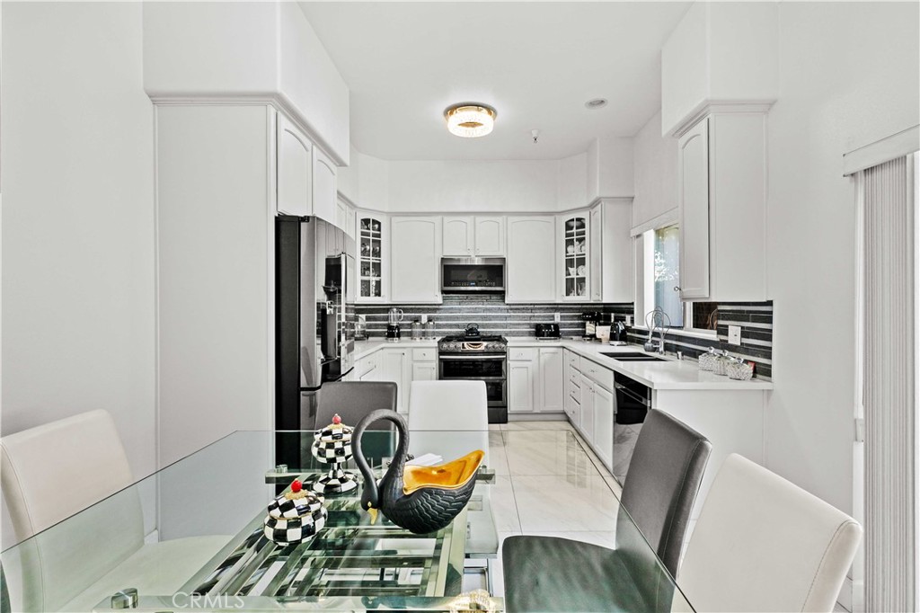 6920 Valmont Street, Unit 5 Tujunga, CA 91042 - Photo 30 of 69 a kitchen with stainless steel appliances kitchen island granite countertop a sink dishwasher a stove a refrigerator a microwave oven with granite countertops and cabinets