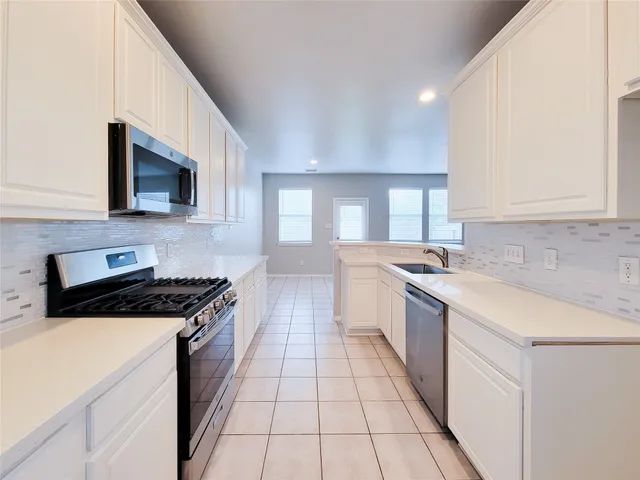 a kitchen with a sink stove top oven and cabinets