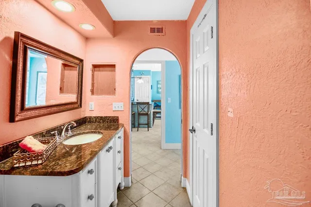 a bathroom with a granite countertop sink and a mirror