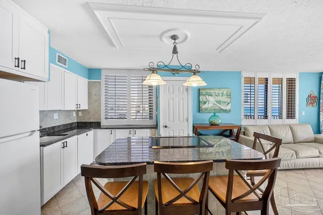 a kitchen with stainless steel appliances a stove a refrigerator and a dining table