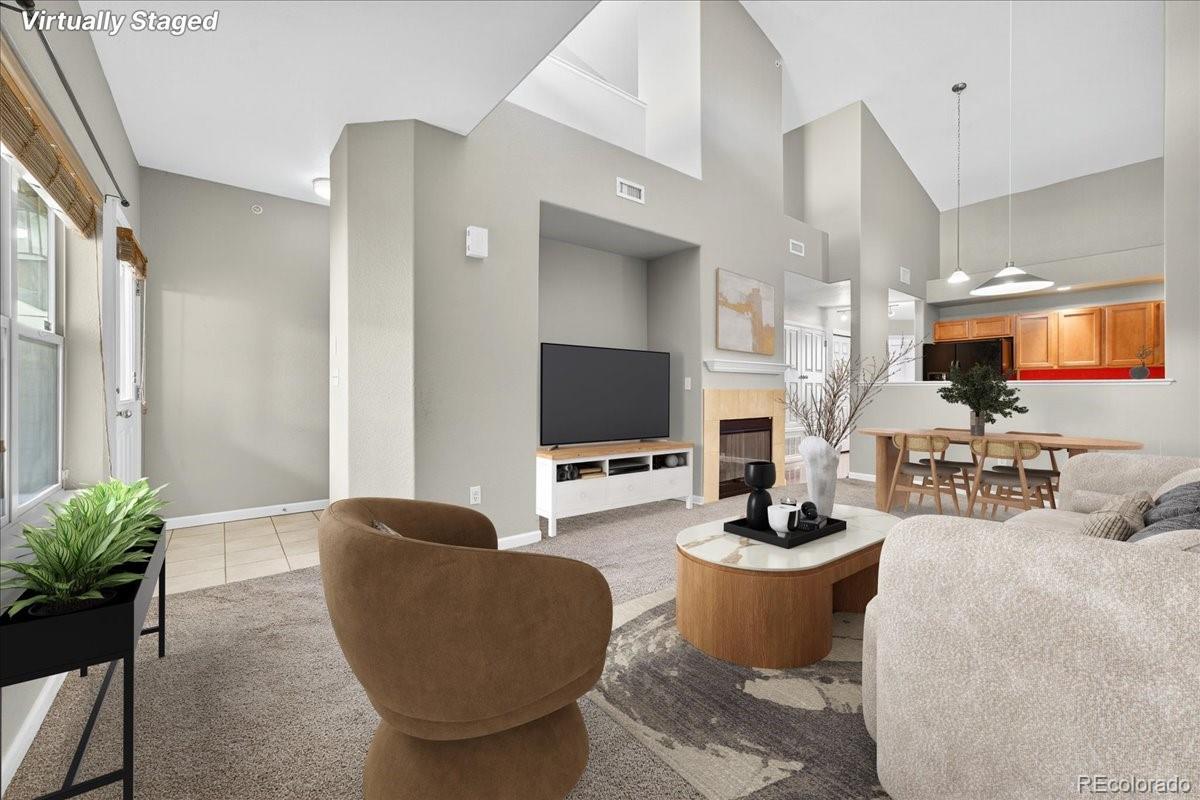 5800 Tower Road, Unit 2411 Denver, CO 80249 - Photo 2 of 28 a living room with furniture a flat screen tv and a fireplace