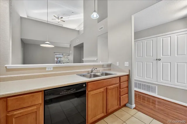 a kitchen with a sink dishwasher and a stove with wooden floor