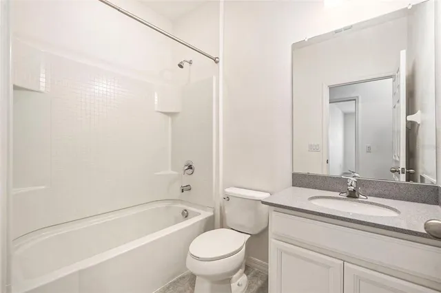 a bathroom with a granite countertop toilet a sink and a bathtub