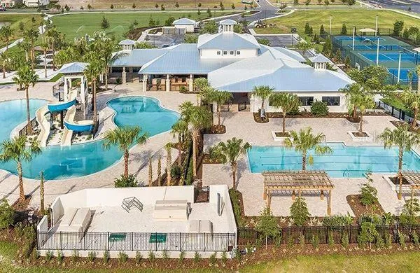 an aerial view of residential houses with outdoor space and swimming pool
