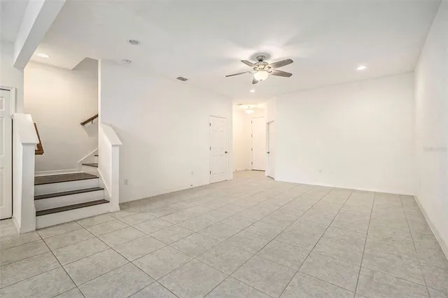 an empty room with a ceiling fan and entryway
