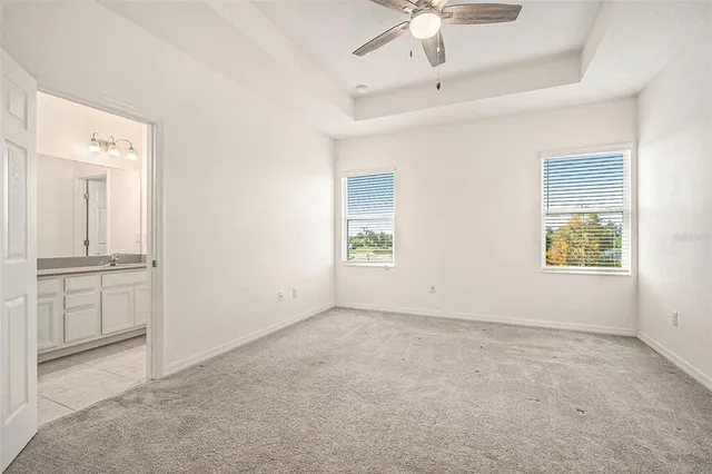 an empty room with windows and cabinet