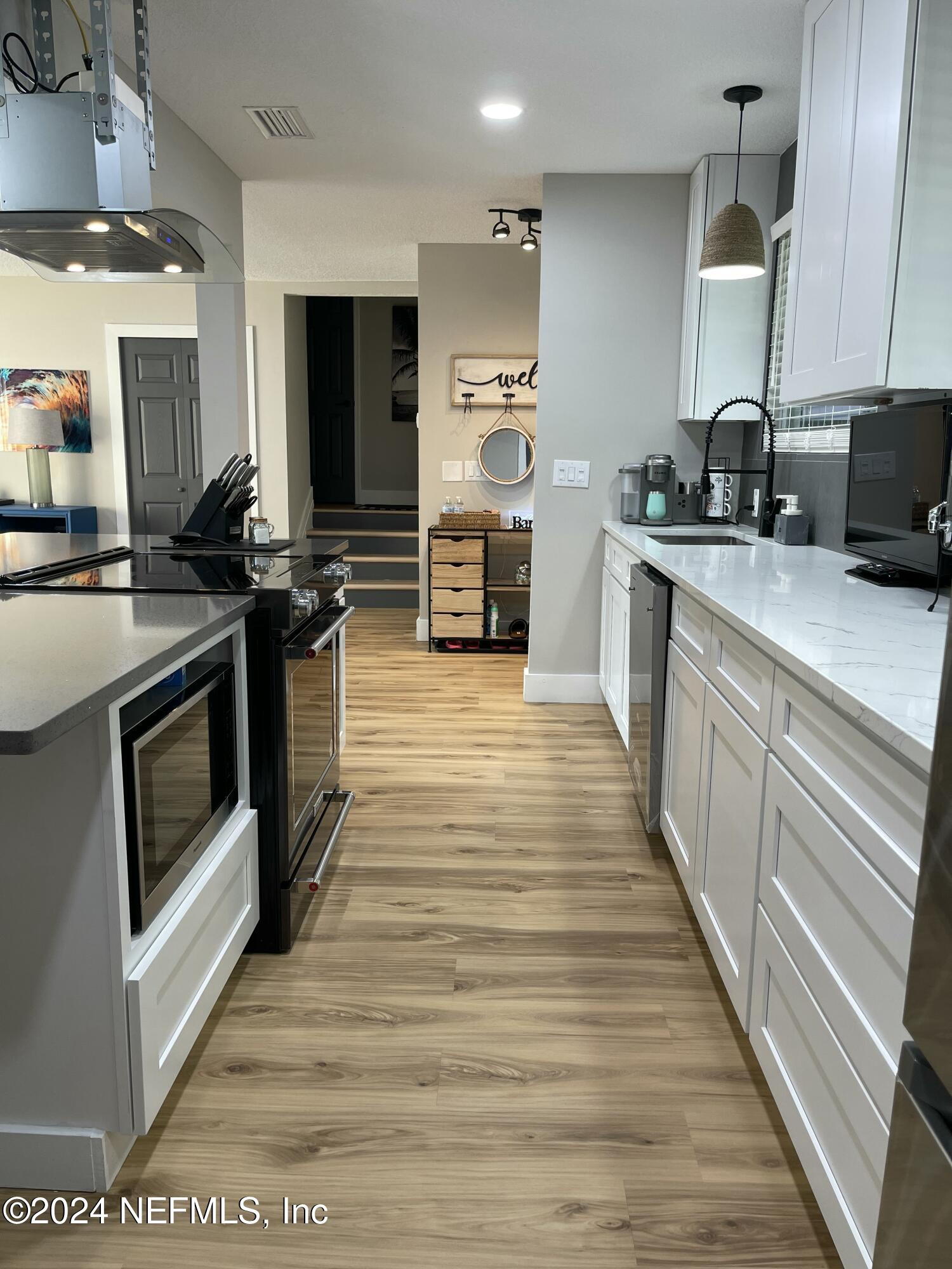 7566 Old Kings Road South Jacksonville, FL 32217 - Photo 7 of 30 a kitchen with stainless steel appliances wooden floor sink and wooden cabinets