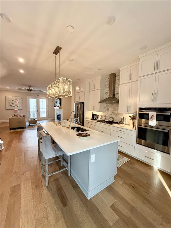 2098 Cortland Road, Unit 31 Alpharetta, GA 30004 - Photo 4 of 16 a kitchen with stainless steel appliances kitchen island granite countertop a sink a stove and a wooden floors