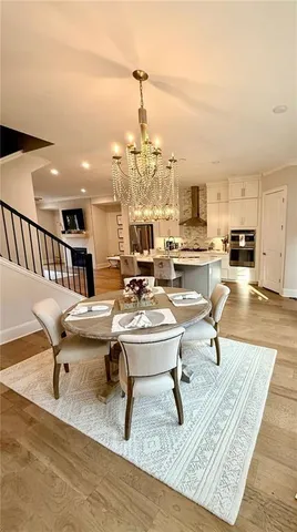 a view of a dining room with furniture a chandelier and wooden floor