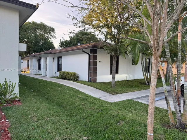 a view of a house with backyard and a tree