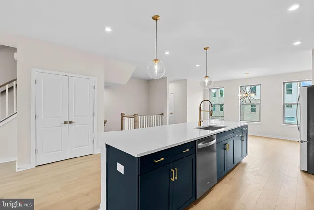 a kitchen with granite countertop a sink a counter space and wooden floor
