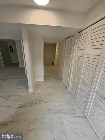 a view of a hallway with wooden floor and entryway