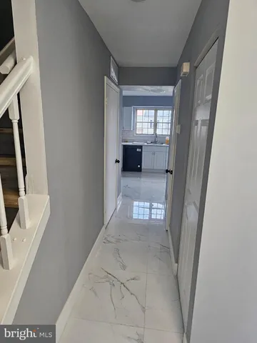 a view of a hallway to a livingroom with furniture and windows