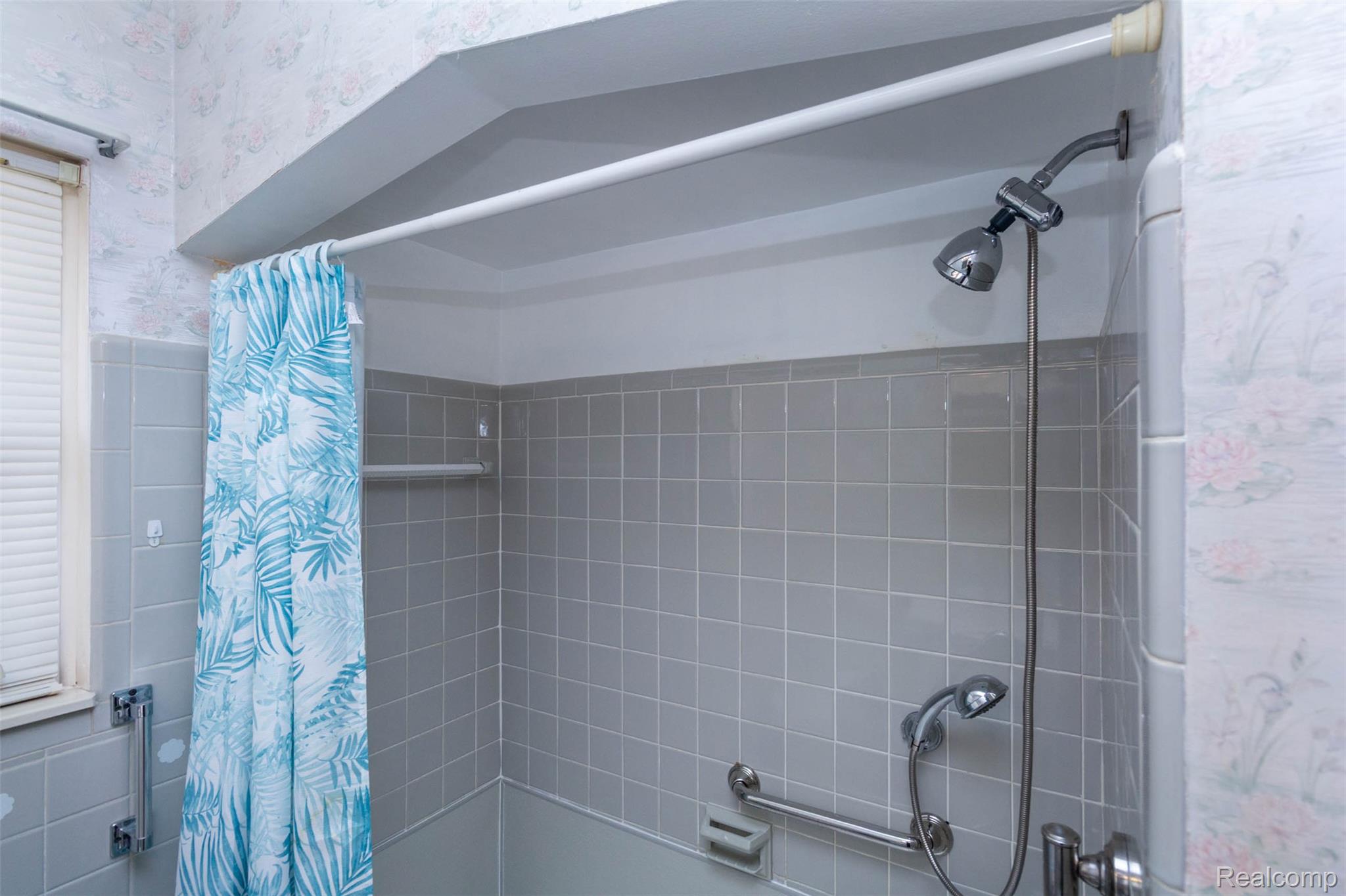 14869 Champaign Road Allen Park, MI 48101 - Photo 18 of 34 Tiled shower stall featuring a fixed showerhead, handheld shower fixture, and grab bars
