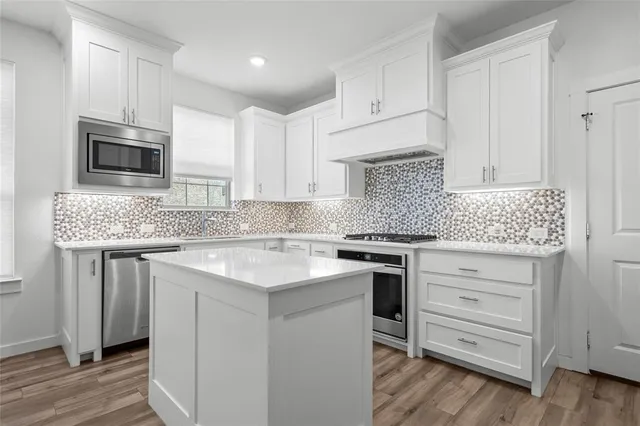 a kitchen with granite countertop white cabinets stainless steel appliances and sink