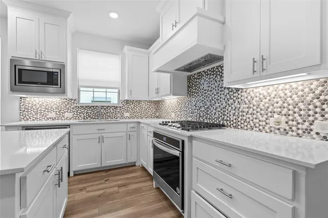 a kitchen with cabinets appliances and a sink