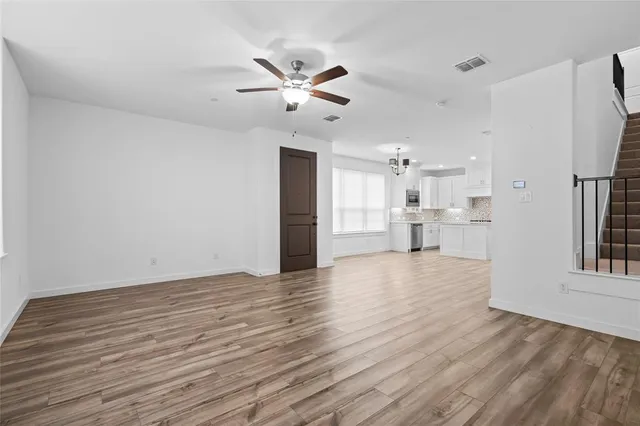 a view of empty room with wooden floor and window