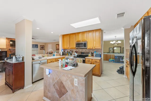 a kitchen filled with a refrigerator a stove a sink dishwasher and a dining table with wooden floor