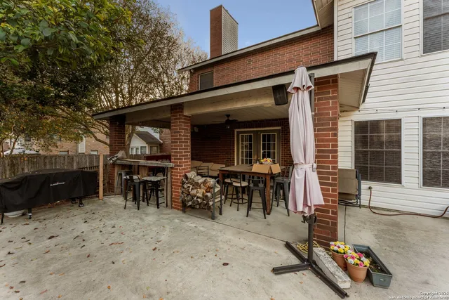 a view of a dinning tables and chairs in the patio in front of a house