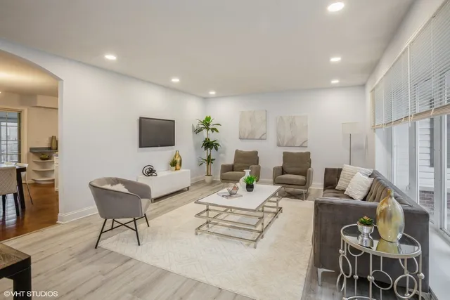a living room with furniture a flat screen tv and kitchen view