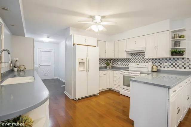 a kitchen with a sink cabinets a refrigerator and a stove top oven