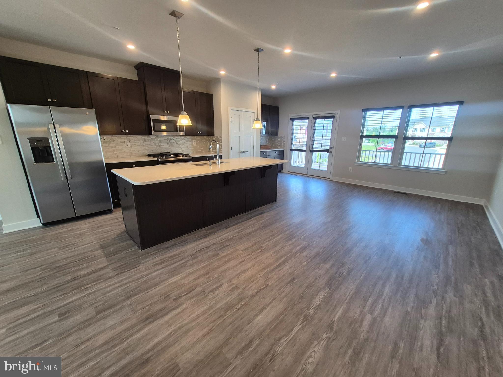 6054 Fallfish Court New Market, MD 21774 - Photo 11 of 28 a large kitchen with stainless steel appliances wooden floors and wooden cabinets
