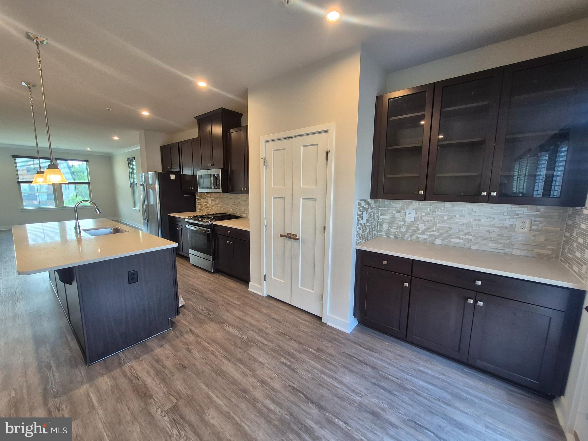 6054 Fallfish Court New Market, MD 21774 - Photo 13 of 28 a large kitchen with stainless steel appliances kitchen island granite countertop a large counter top and wooden cabinets