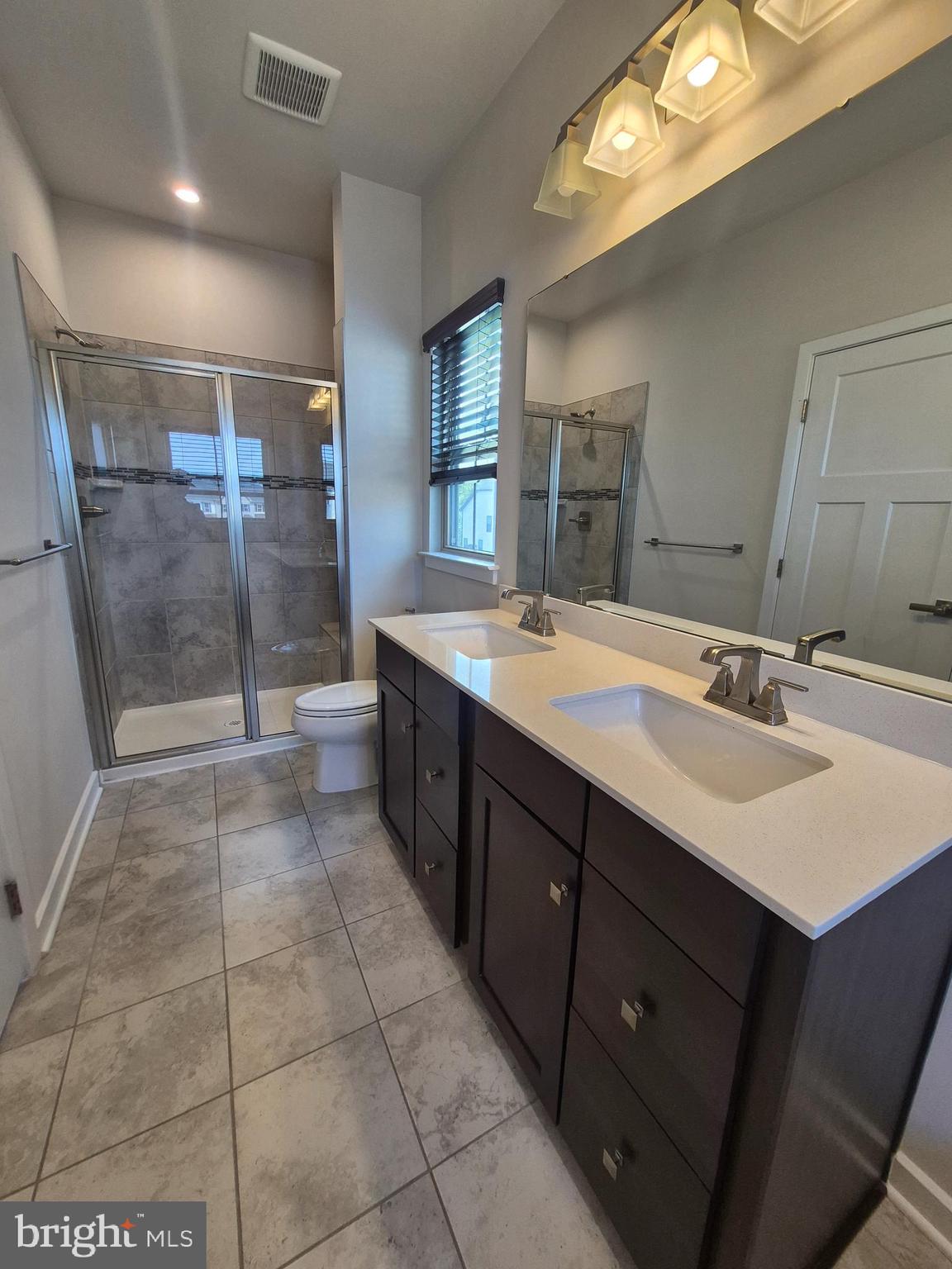 6054 Fallfish Court New Market, MD 21774 - Photo 23 of 28 a bathroom with a sink a vanity a mirror and a shower