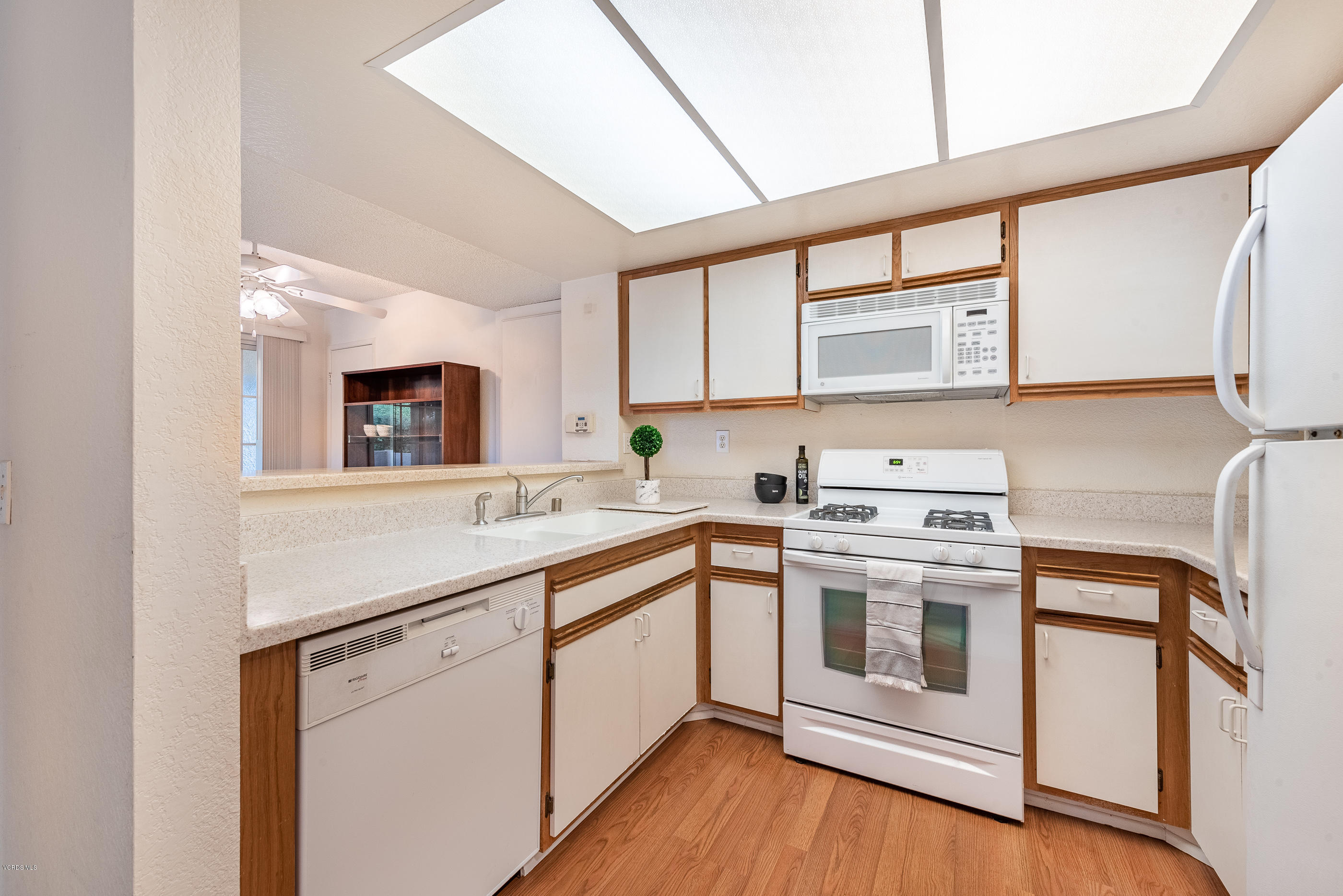 1007 Waltham Road, Unit C Simi Valley, CA 93065 - Photo 8 of 25 a kitchen with stainless steel appliances granite countertop a stove and white cabinets with wooden floor