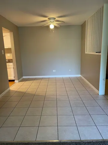 a view of an empty room and window of a kitchen