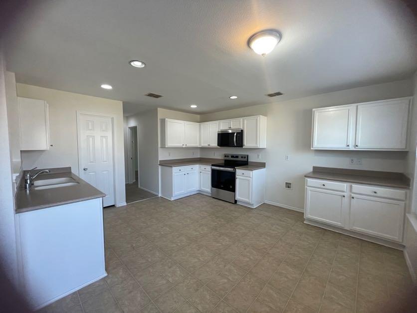 12645 Pricklybranch Drive Fort Worth, TX 76244 - Photo 2 of 21 a kitchen with stainless steel appliances granite countertop a stove a sink a refrigerator and white cabinets