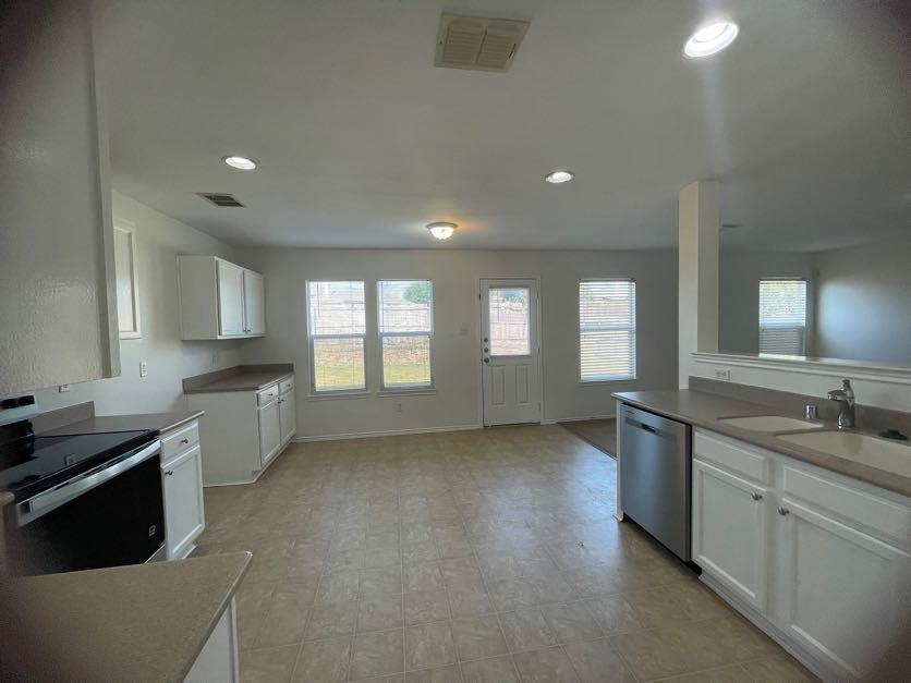 12645 Pricklybranch Drive Fort Worth, TX 76244 - Photo 3 of 21 a large kitchen with a sink and dishwasher a stove top oven with wooden floor