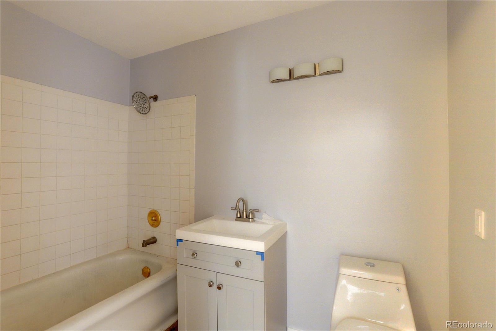 4315 Balsam Street Wheat Ridge, CO 80033 - Photo 15 of 34 a bathroom with a sink a toilet and bathtub