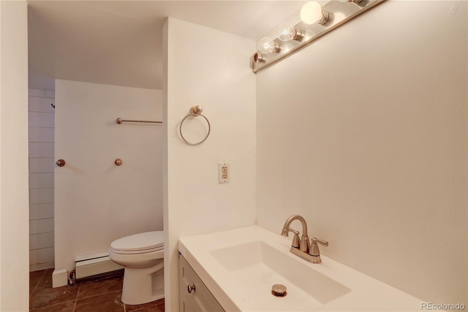 4315 Balsam Street Wheat Ridge, CO 80033 - Photo 19 of 34 a bathroom with a sink toilet and shower