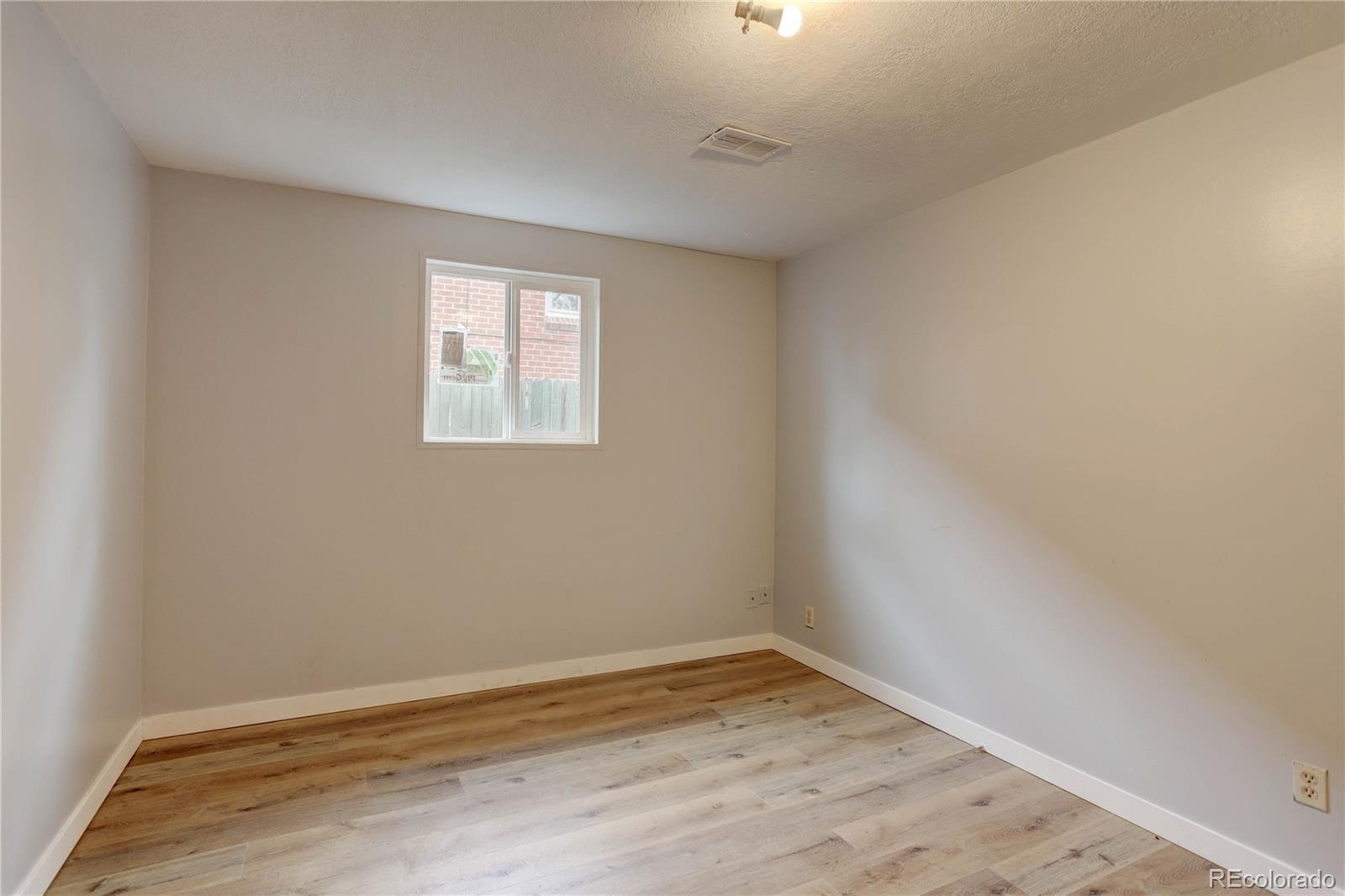 4315 Balsam Street Wheat Ridge, CO 80033 - Photo 24 of 34 an empty room with wooden floor and windows