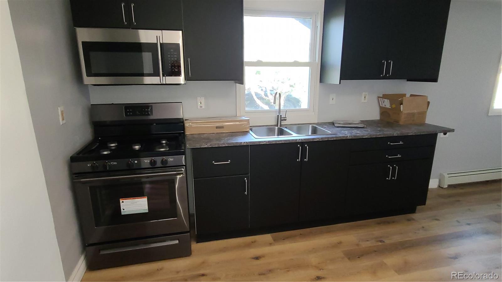 4315 Balsam Street Wheat Ridge, CO 80033 - Photo 8 of 34 a kitchen with a sink stove and microwave