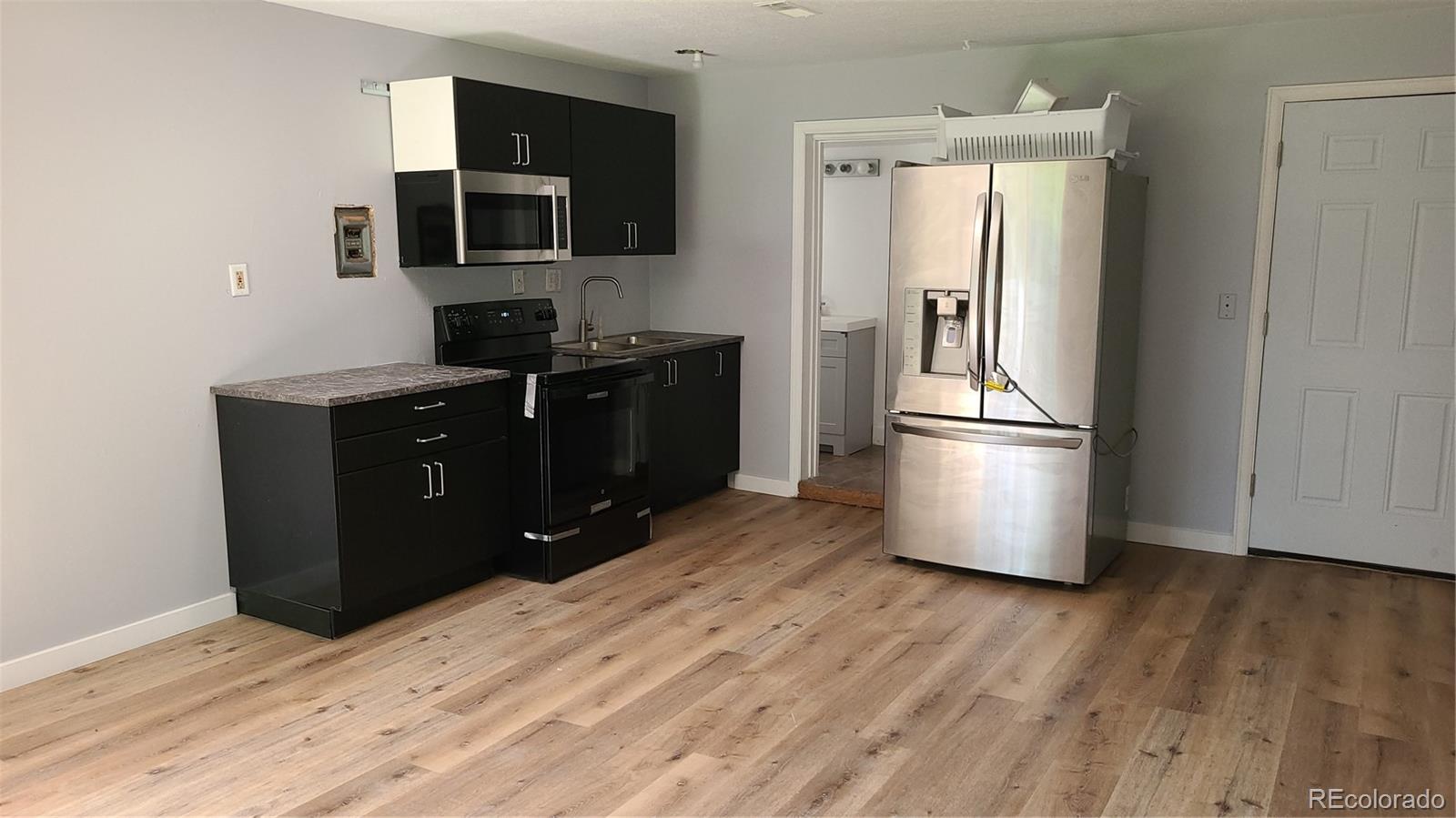 4315 Balsam Street Wheat Ridge, CO 80033 - Photo 9 of 34 a kitchen with a refrigerator and a stove top oven