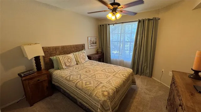 a bedroom with a bed and a flat tv screen on dresser