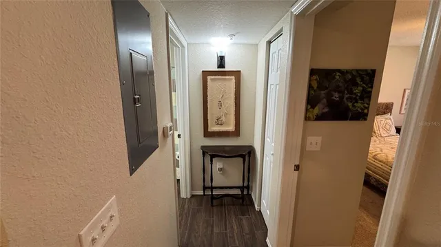 a view of a hallway with wooden floor and closet