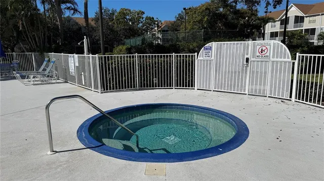 a view of a swimming pool with a small yard and wooden fence